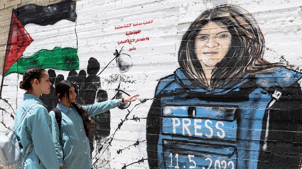 Palestiner framför en muralmålning av den dödade Al Jazeera-journalisten Shireen Abu Akleh.