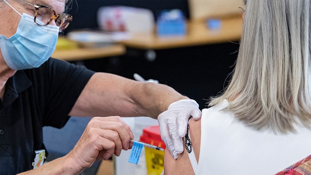 En ung kvinna blir vaccinerad av en äldre kvinna.