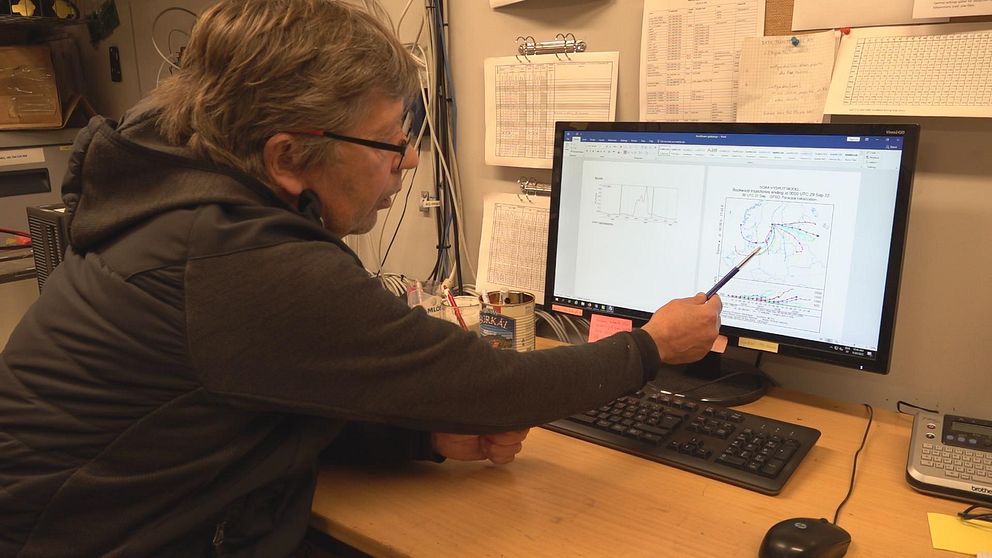 Anders Båth sitter vid en skärm och visar en graf.
