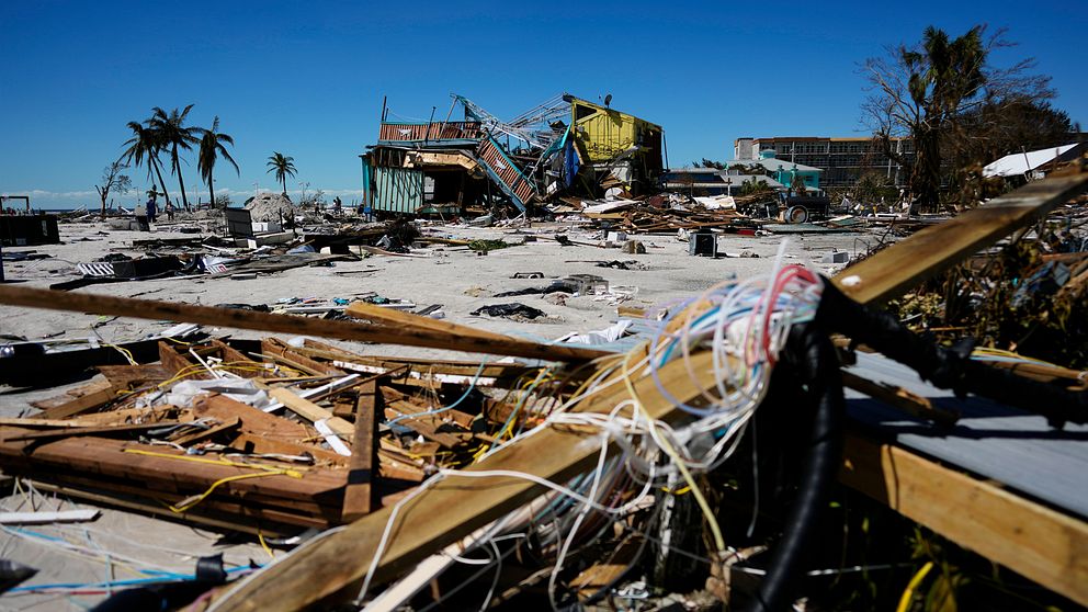 Hus totaltförstörda i Fort Myers Beach. Skräp och elsladdar ligger i förgrunden och palmer sticker upp där bakom.
