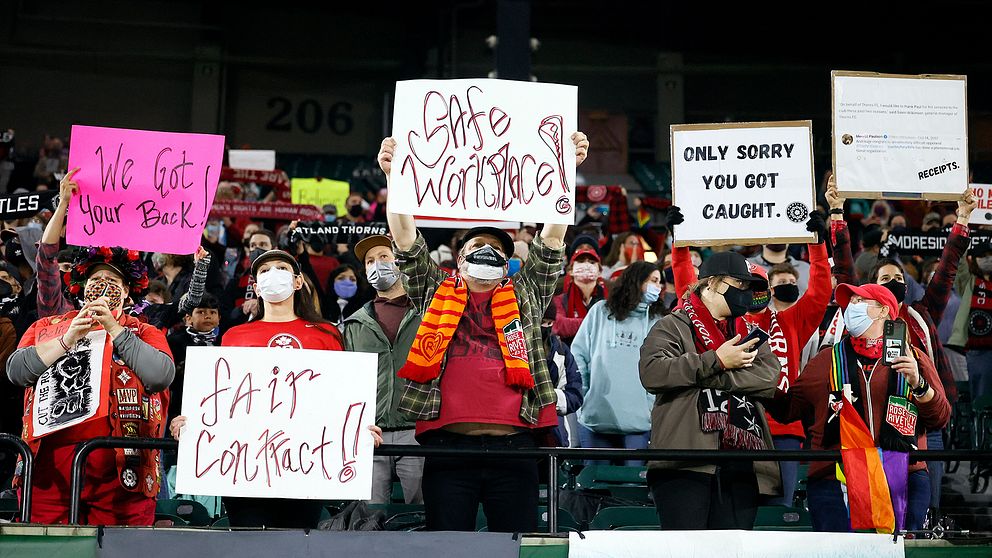 Fans som håller upp skyltar under matchen Houston Dash – Portland Thorns FC.