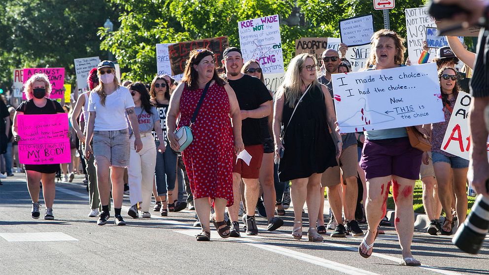 En stor grupp människor med plakat, mest kvinnor, som protesterar mot att rätten till abort har begränsats i USA.