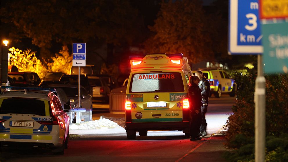 En ambulans och en polisbil står parkerade invid en boendeparkering.