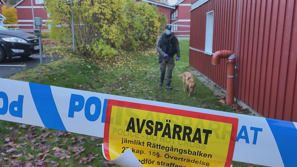 Avspärrning i området Bojsenburg i Falun, och en hudn och hundförare är i bakgrunden.