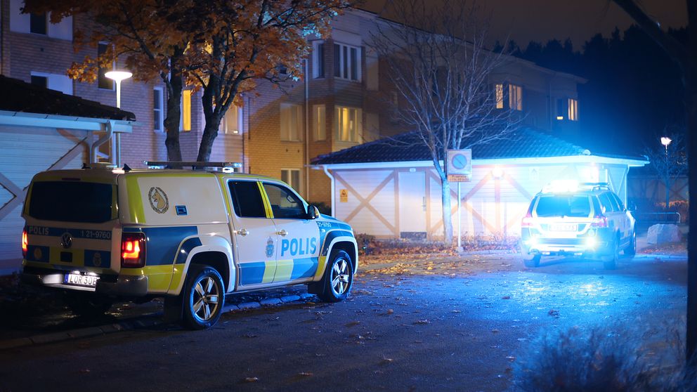 En bild på två polisbilar i ett bostadsområde.
