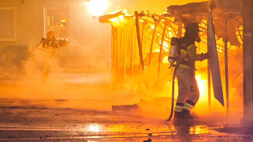 Räddningstjänsten släcker brand i miljöhus.