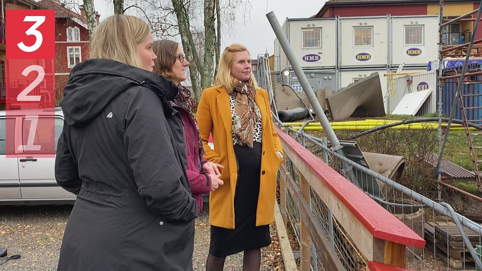 tre kvinnor som ingår i Dalauppropet, står vid en byggarbetsplats i Falun och kollar på när de bygger.