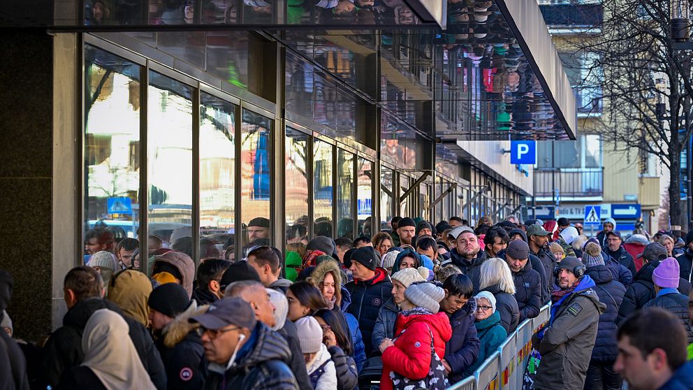 En bred och lång kö av människor står utanför Migrationsverket i Sundbyberg och väntar på att få komma in.