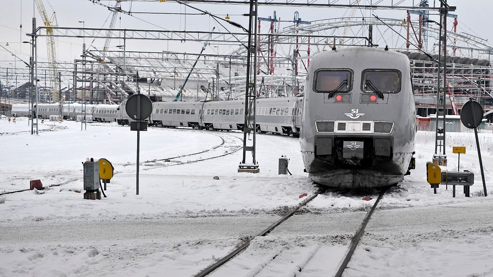 Ett tåg står inne på en snöig bangård.