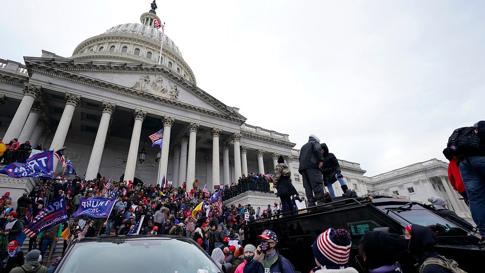 USA:s kongress Kapitolium med folkmassor utanför som försöker ta sig in i byggnaden.