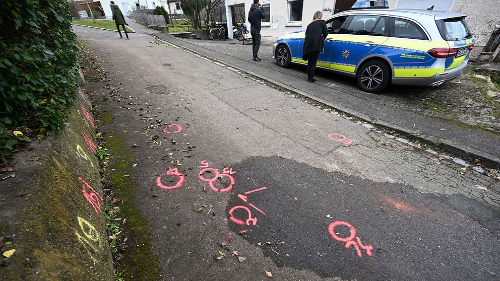 Polisen målar markörer i gult och rosa på marken