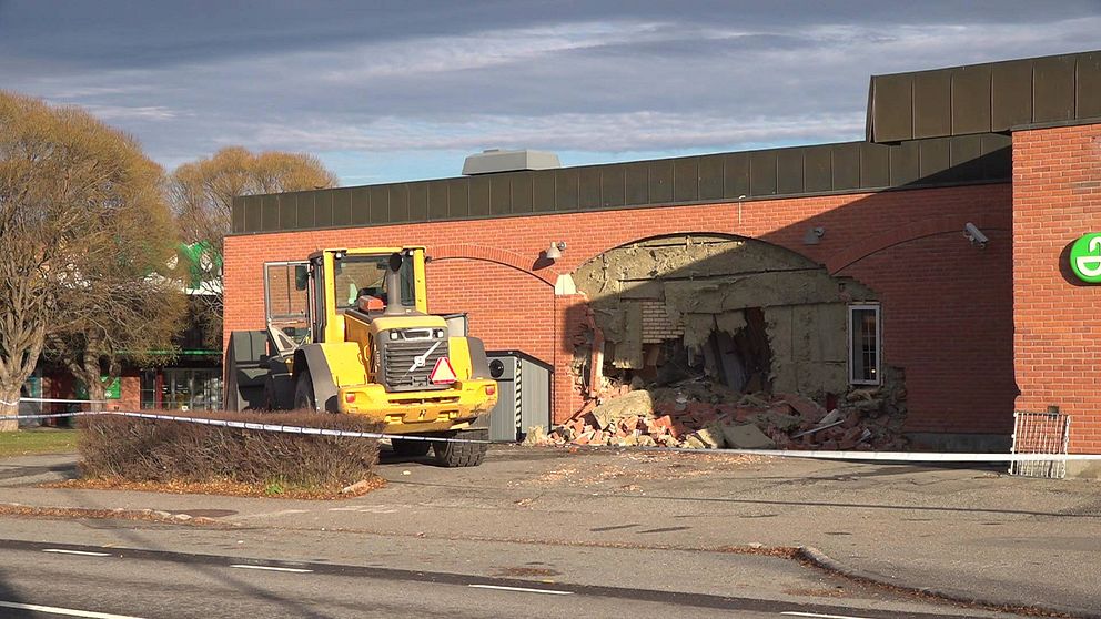 Det var i slutet av oktober som någon körde in en hjullastare i en affärslokal i Bräcke. På bilden ser man en gul hjullastare vid en tegelbyggnad. I tegelbyggnaden är det ett hål. Framför allt ett blåvitt polisavspärrningsband.