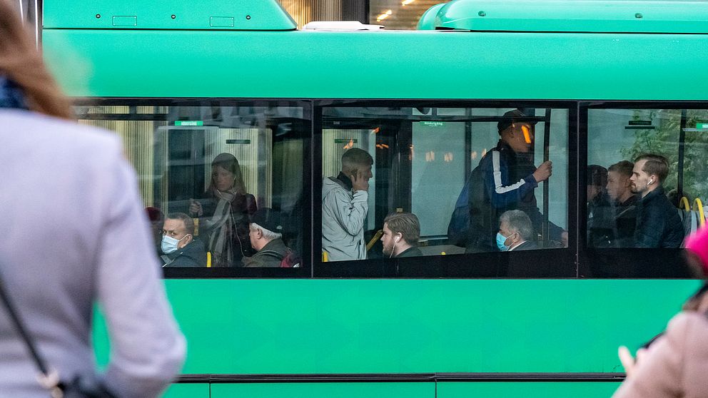 Passagerare ombord på en grön buss.