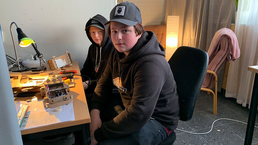 Två elever sitter vid ett skrivbord där de påbörjat byggandet av kartongbilar