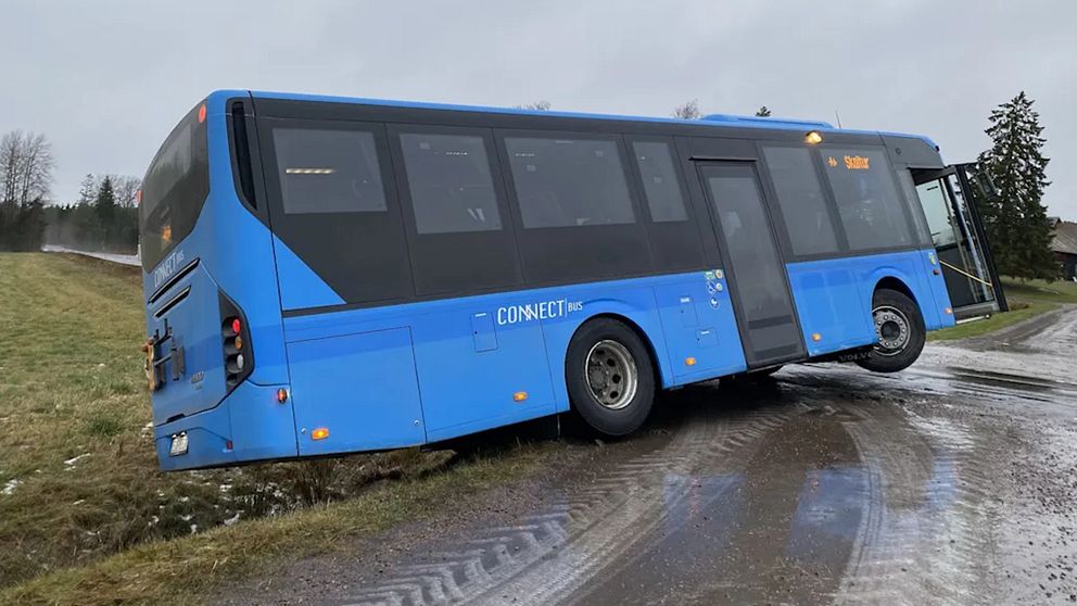 En buss som kanat ner i diket, stående med ett framhjul i luften.