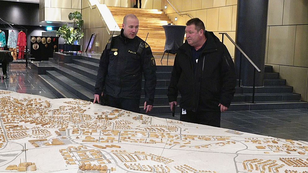 På bilden ser du en polis och Kirunas säkerhetschef Jan Lundmark framför en enorm karta på kommunen.