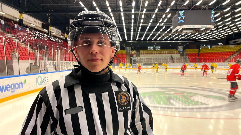 Hugo Casparsson som är domaransvarig på Linköpings Hockey Club är klädd i domarkläder i en ishall.