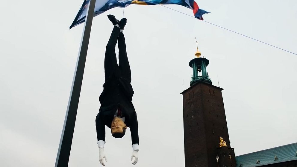 En docka föreställande Turkiets president hänger upp och ned utanför Stockholms stadshus.