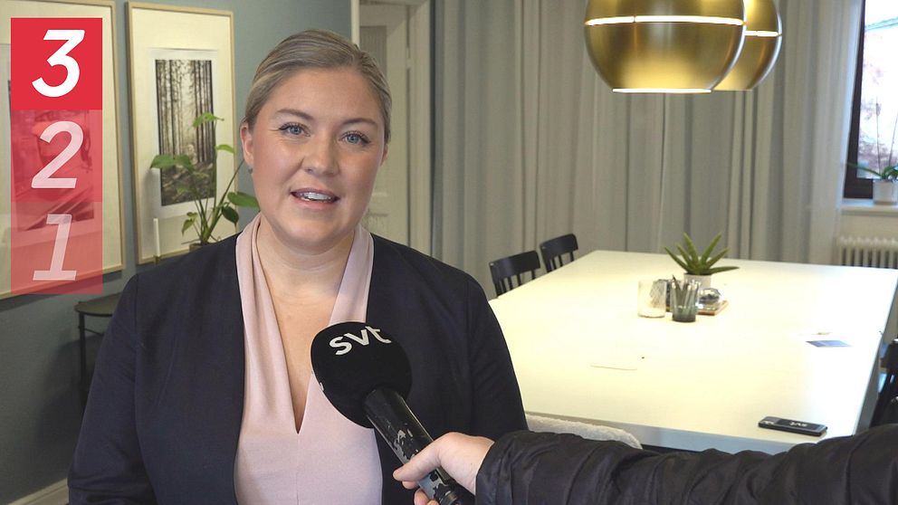 Mäklare som står och blir intervjuad