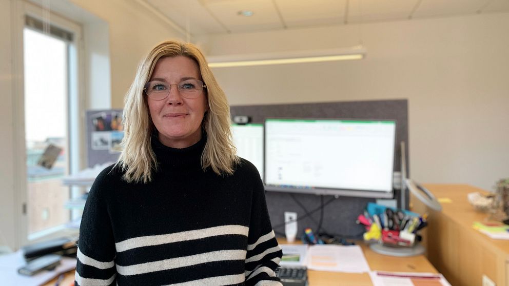 Susann Ericsson står på sitt kontor. I bakgrunden syns två datorskärmar.