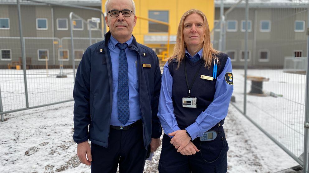 Mohamad Mehanna och Åsa Bergström framför kriminalvårdsanstalten Rödjans nya tvåvåningsanstaltsbyggnad, som går i gult och grått.
