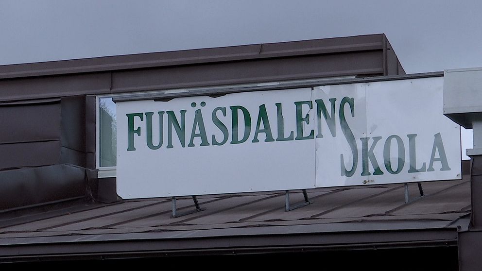 Skylt där det står ”Funäsdalens skola” i stor gröna bokstäver mot vit bakgrund.