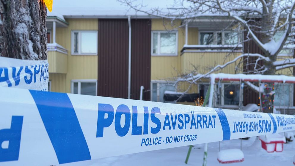 En bild på ett hyreshus på Hertsön i Luleå och ett  av polisens avspärrnigsband.