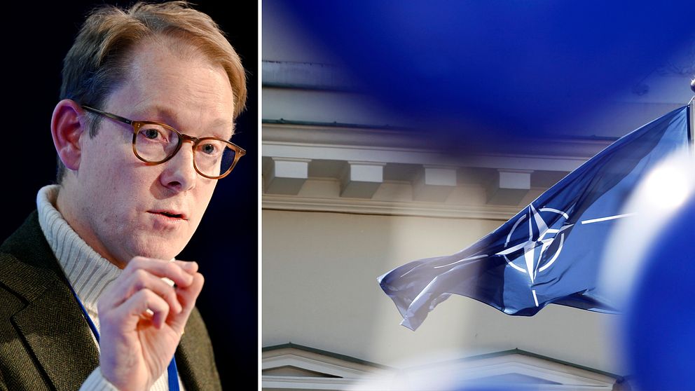 Tobias Billström och en bild på Natos flagga.