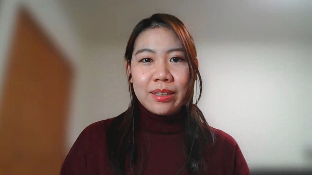 Mei Azakuma i långt brunt hår och vinröd tröja