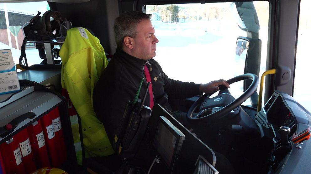 Brandmannen Mikael Frithiof  sitter i förarsätet i en brandbil