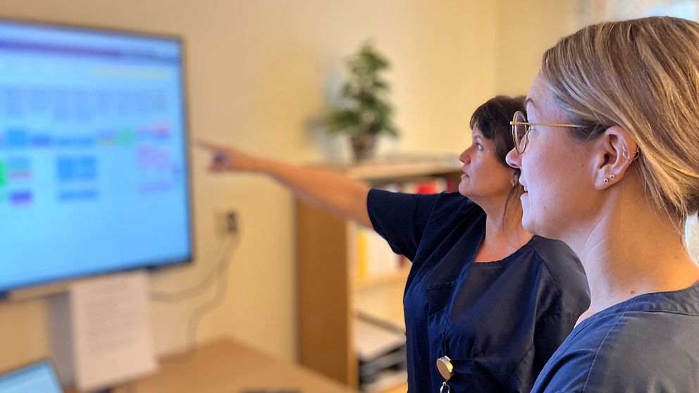 Personal inom hemtjänsten i Byske tittar på en skärm där deras schema visas.