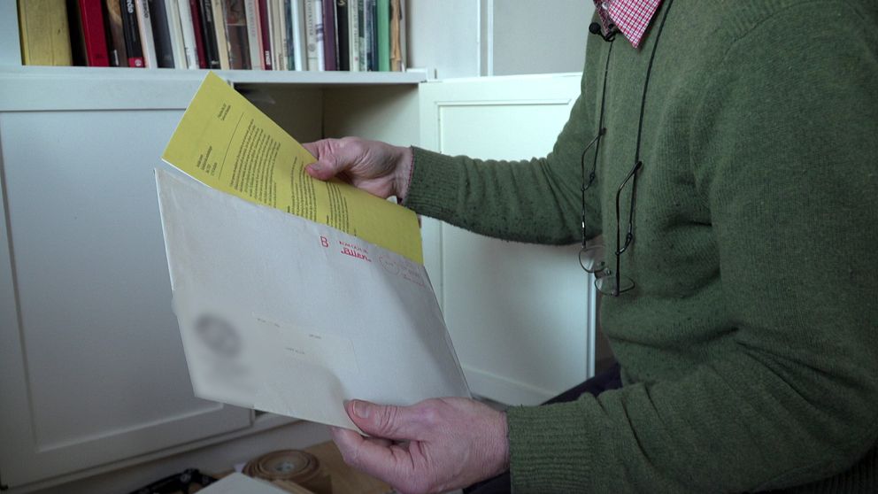 Ett brev med gult papper inuti landar in i en mans brevlåda.