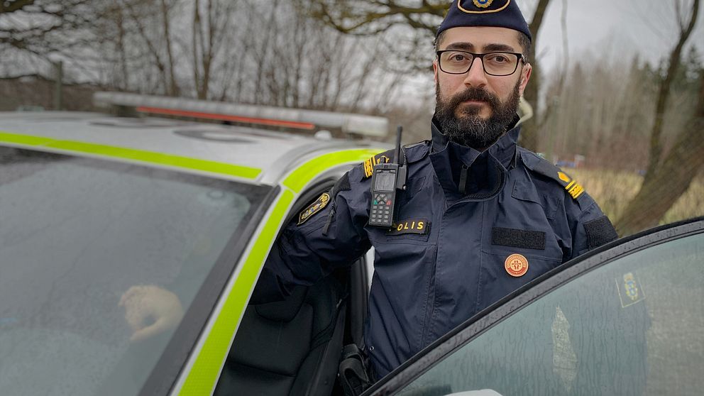 Roj Darwich, skyddsombud och utredare vid polisen i Gävleborg står vid en polisbil.