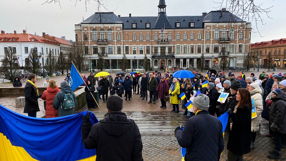 Ett torg med människor många håller den gulblå ukrainska flaggan