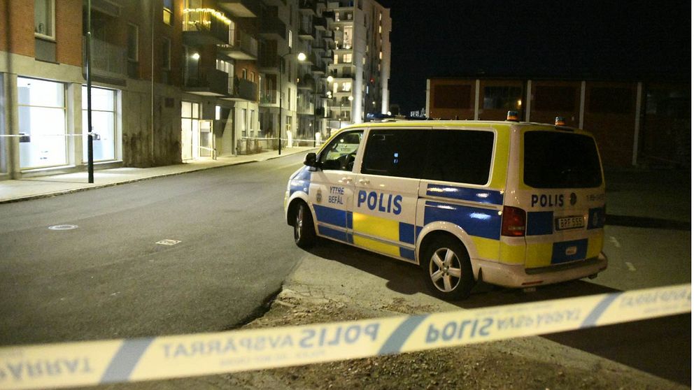Polisbuss innanför avspärrningsband.