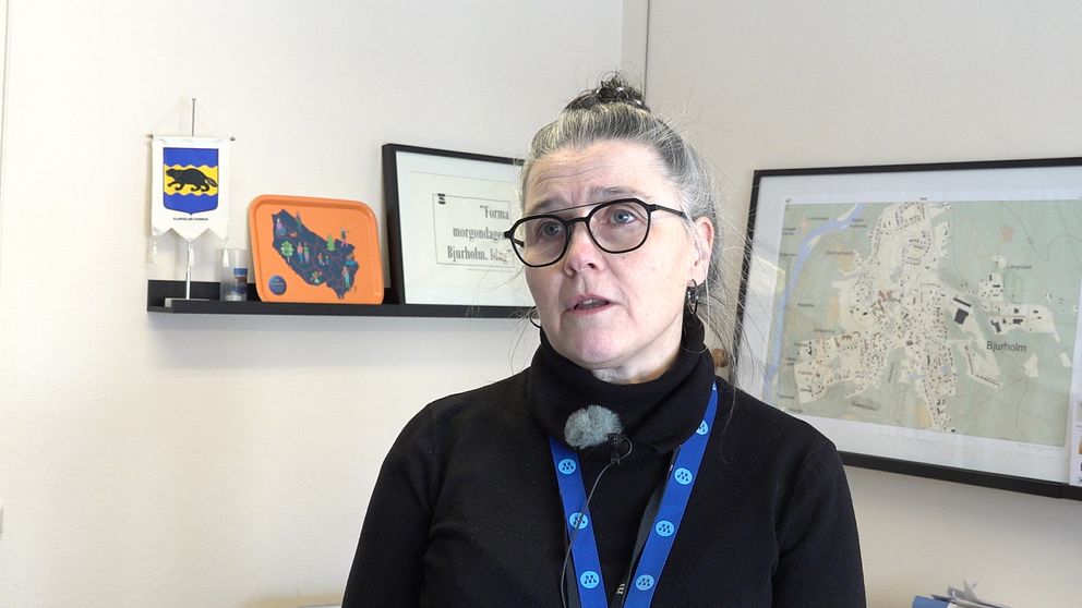 Moderaten Christina Lidström, kommunstyrelsens ordförande i Bjurholm, står inne på sitt kontor. Hon har grått hår uppsatt i knut, svart tröja och nyckelband med M-loggan runt halsen.
