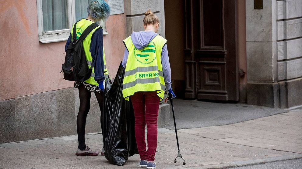 Två unga tjejer som plockar skräp på Götgatan i Stockholm