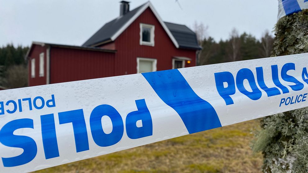 Polisavspärrning framför ett rött trähus.