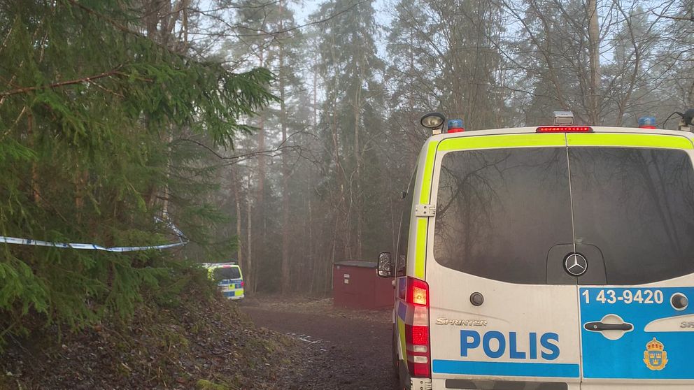 Polisbil i skogsområde i Taberg utanför Jönköping där en kvinna hittats död. Polisen misstänker att hon mördats.