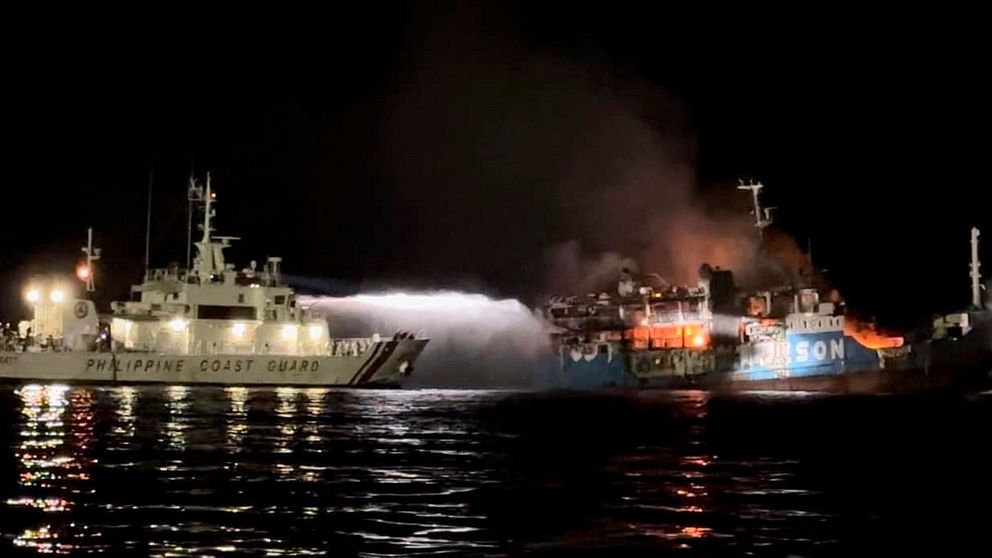 Ett skepp från Filippinernas kustbevakning sprutar vatten på den brinnande last- och passagerarfärjan.
