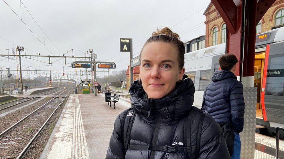 Pendlaren Karin Lövgren står framför ett tåg på Halmstad station.
