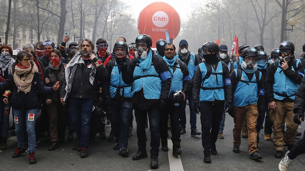 Franska unionens säkerhetsstyrkor täckta med ansiktsmasker deltar i demonstrationen.