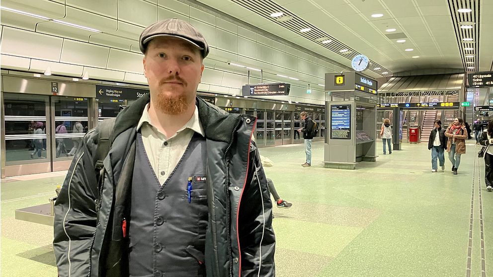 Anton Pajaujis, står i MTR-uniform på Stockholm city pendeltågsstation.