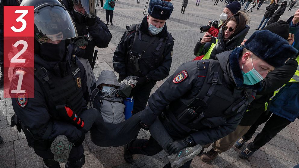En person grips av ryska poliser i Moskva, de bär personen i benen och armarna från en gata där protester mot Rysslands invasion av Ukraina hållits.