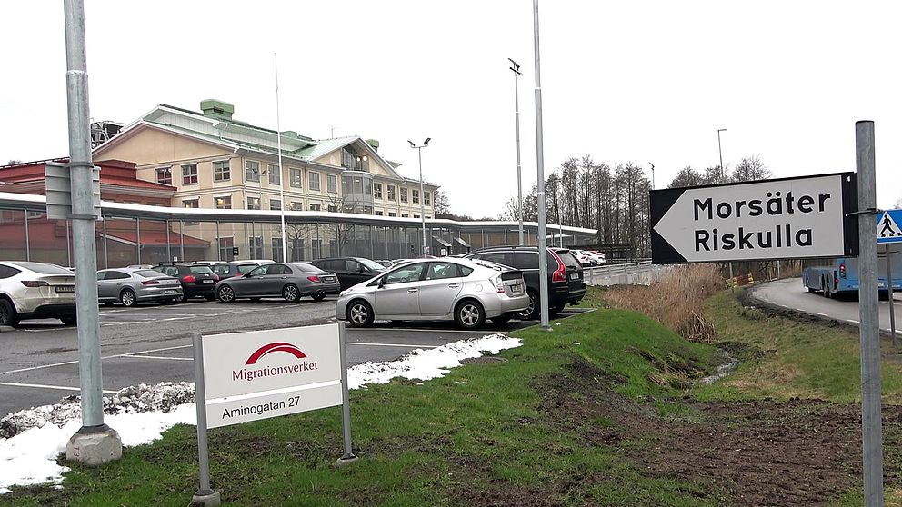 Exteriör på Migrationsverkets förvar i Mlöndal. På bilden syns bilar parkerade framför huvudbyggnaden, snö och en skylt.