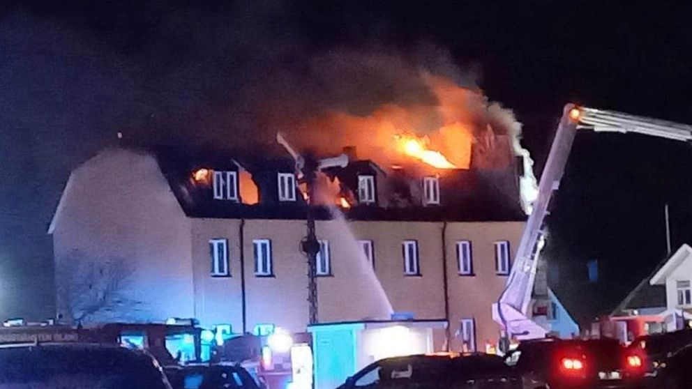 Brand i flerfamiljshus i Borgholm på Öland – räddningstjänsten kämpar mot lågorna som slår upp från taket.