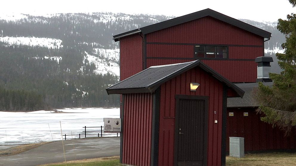 Ett rött hus med svarta knutar och svart tak står vid Åresjön. Bilden visar reningsverket i Vik.