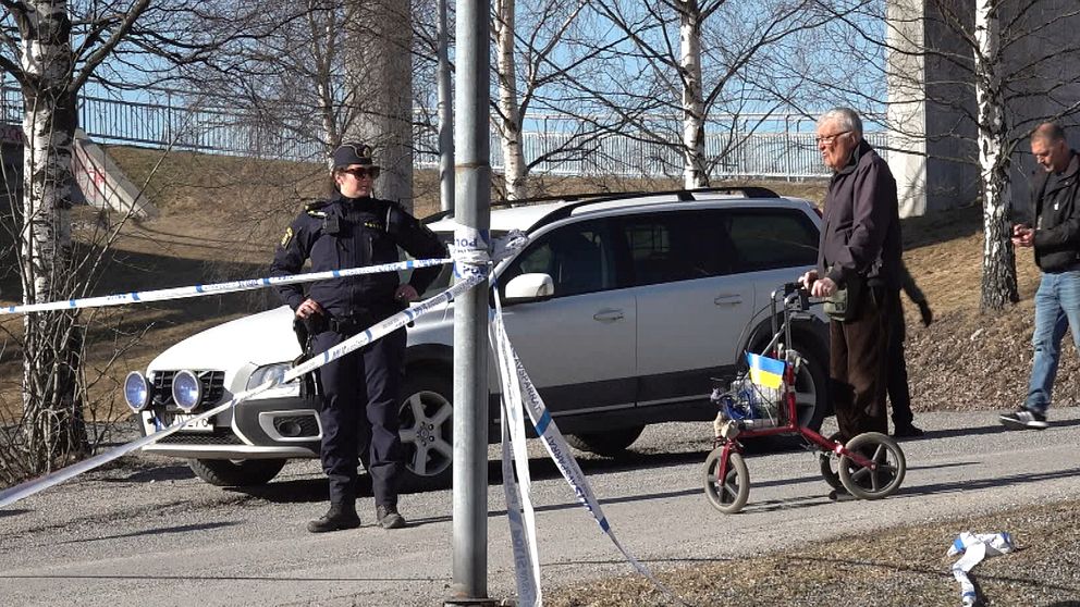 Olof Wiborgh står med en röd rullator vid polisavspärrningarna i Bredsand.