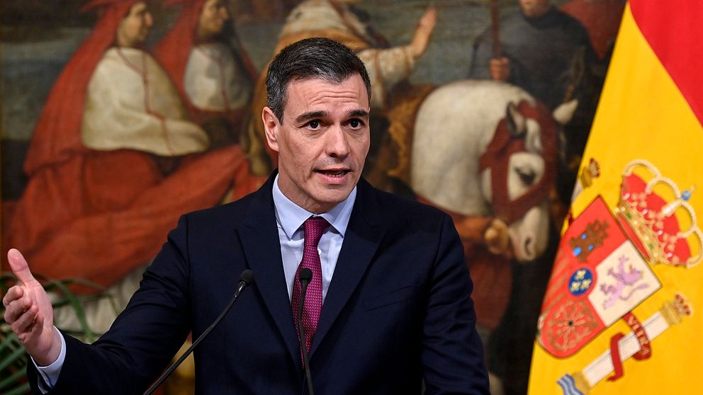 Premiärminister Pedro Sánchez framför spanska flaggan