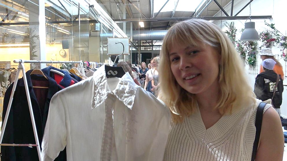 Besökaren Ebba Sundström håller upp ett en skjorta som hon bytt till sig.